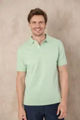 Chomba verde agua de algodón pigmentado con cuello clásico y cartera con botones color naranja. Corte clásico y mangas cortas.