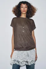 Vestido de punto marrón oscuro, sin mangas y cuello redondo, con un ruedo inferior de encaje blanco.