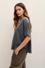 Remera de manga corta color gris oscuro con efecto desgastado, escote redondo amplio y corte holgado.