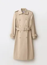 Trench coat de corte recto y diseño largo en color beige. Presenta cierre de doble botonadura, cuello con solapas de muesca, trabillas en los hombros y en los puños, y cinturón desmontable con hebilla a juego. Incluye dos bolsillos laterales y abertura posterior en el bajo.
