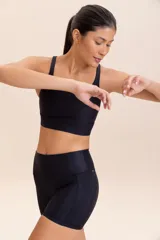 Top deportivo de compresión media con diseño de espalda cruzada y breteles finos. Confeccionado en tejido acanalado con un acabado de brillo sutil, cuenta con copas removibles y tecnología de ajuste adaptable.