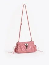 Bandolera de cuero vacuno color marrón con acabado brillante. Presenta un diseño estructurado con herraje metálico tipo candado y llave colgante en el frente, además de detalles de tiras laterales. Incluye correa de hombro y cierre superior.