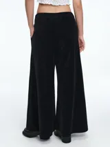 Pantalon de corte amplio y silueta relajada, confeccionado en pana negra. Presenta cintura elástica y bolsillos laterales.
