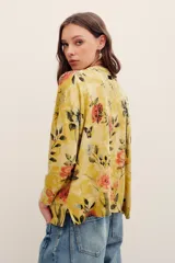 Sweater de punto color mostaza con estampado floral y de mariposas, cuello redondo y mangas largas.