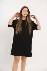 Vestido corto negro de corte holgado y mangas cortas. Tejido de punto acanalado.