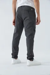 Pantalón cargo gris oscuro, corte slim, con cierre de botón y cremallera, trabillas para cinturón y bolsillos cargo con botón.