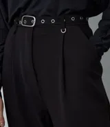 Pantalón de sastrería corte wide leg color negro, con pliegues delanteros, trabillas y cinturón incluido con detalles metálicos. Confeccionado en tejido estructurado con caída fluida.