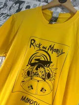 Remera amarilla con estampado de Rick y Morty en un ovni y el logo de la marca Makosh.