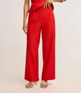 Pantalón de sastrería corte wide leg, de tiro alto con cintura doble y detalle de remaches metálicos en la parte frontal.