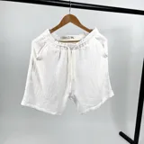 Bermuda blanca de tela muselina con bolsillos delanteros y traseros, corte vestir.