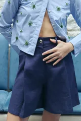 Bermuda de lino color azul marino, de corte sastrero con pinzas frontales, cierre y botón metálico personalizado.