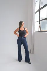 Pantalón de jean corte oxford, color azul oscuro, con tiro alto y cierre frontal con botón metálico.