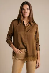 Camisa de satén color marrón, de corte clásico con cuello camisero y cierre frontal de botones. Presenta mangas largas con puños abotonados y un delicado detalle de encaje en el ruedo.