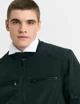 Campera de estilo casual con cierre frontal, cuello alto con broche y bolsillos laterales con cierre. Presenta un diseño liso y funcional, ideal para uso diario.