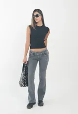 Pantalón de jean gris oscuro con efecto lavado, corte tiro bajo y diseño acampanado con bolsillos frontales decorativos.