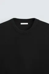 Camiseta negra de punto con cuello redondo, manga corta y corte regular. Tejido de viscosa con acabado en rib.