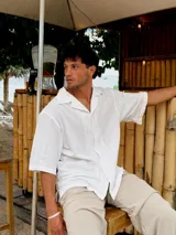 Camisa blanca de corte amplio, con cuello clásico y mangas cortas. Ideal para usar en verano.