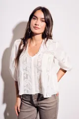 Blusa negra de algodón peinado con calce oversize, escote en V, mangas tres cuartos abullonadas y detalles de encaje y bordados en el frente y mangas.