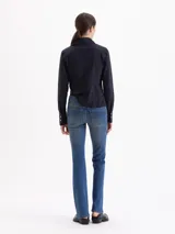 Jeans de corte oxford con tiro medio, ajustado en muslos y rodillas con apertura hacia el ruedo. Presenta un lavado matizado con efecto vintage y costuras en tono contrastante.