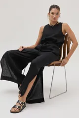 Pantalón de pierna ancha confeccionado en lino, con cintura elástica, tiras regulables y abertura en el bajo.