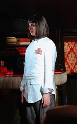 Remera blanca de manga larga superpuesta a una camisa blanca de manga larga, ambas con cuello. La prenda exterior tiene un estampado frontal en naranja con texto censurado inspirado en la película Pulp Fiction.