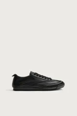 Zapatillas de estilo retro para hombre, de color negro, con diseño monocolor y cordones a tono. Presentan una parte superior con combinación de piezas y suela dentada.