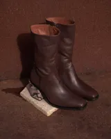 Botas de cuero color marrón con caña media, punta cuadrada y cierre lateral. Taco geométrico con estampado de víbora.