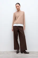 Sweater azul marino de manga larga con cuello redondo, combinado con una camisa celeste que se asoma por debajo.