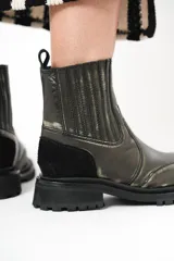 Botas de cuero negro con elásticos laterales, detalle de gamuza en el talón y suela de goma con plataforma.