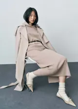 Falda midi de punto con diseño evasé, confeccionada en tejido mezcla de lana. Presenta tiro medio y cintura con elástico para mayor comodidad.