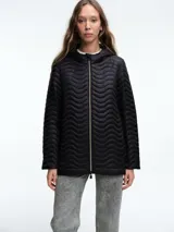 Campera negra con diseño acolchado de ondas horizontales, cierre frontal completo, capucha integrada y mangas largas.