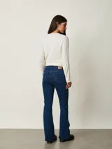 Pantalón de jean negro de corte flare, con tiro medio y bolsillos delanteros y traseros.