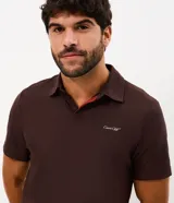 Remera polo deportiva de hombre marca Get Over, color marrón, confeccionada en tejido tecnológico de poliamida con tecnología dry y acabado liviano. Cuenta con cuello polo, cartera de botones y mangas cortas.