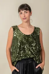 Blusa sin mangas confeccionada en tela cubierta de lentejuelas doradas y plateadas, con escote redondo y corte holgado.