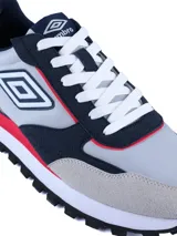 Championes urbanos Umbro modelo Venturi, con diseño multicolor en tonos gris, azul marino, blanco y detalles en rojo. Confeccionados en una combinación de cuero y malla, cuentan con suela de EVA y TPR para mayor confort y tracción.