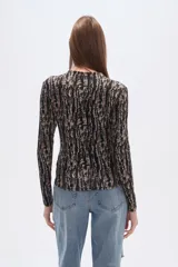 Remera de manga larga con cuello alto y estampado animal print en tonos marrones.