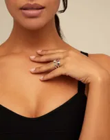 Anillo abierto plateado con dos pequeñas cabezas de clavo.