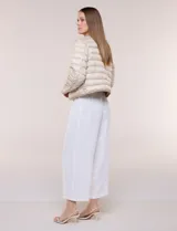 Campera puffer corta de diseño reversible y liviano, marca Michael Kors. Cuenta con acabado resistente al agua, diseño acolchado con matelaseado horizontal, cuello redondo a la base sin solapa ni capucha, cierre frontal completo con botones de presión metálicos, bolsillos laterales funcionales y ribetes a tono. Largo a la cintura y empacable en su propia bolsa de guardado.