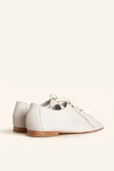 Zapato tipo oxford plano de cuero vacuno en color azul marino, con cordones al tono y suela de cuero.