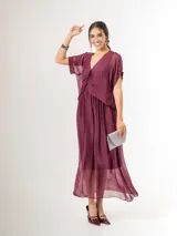 Vestido midi de seda italiana color bordó, con escote en V, sobrecapa fruncida y diseño fluido. Cuenta con mangas cortas amplias y elástico en la cintura.