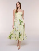 Vestido midi de algodón color amarillo con estampado floral, marca Julia Jordan, escote recto, breteles anchos y falda de caída amplia con bolsillos laterales.