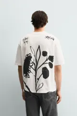 Camiseta de corte relajado confeccionada en algodón, con cuello redondo, manga corta y estampado de texto en contraste en el frente.