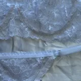 Conjunto de lencería de encaje con aro, compuesto por un soutiene de diseño delicado y una bombacha cavada con tiras elásticas regulables en los laterales.