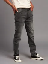 Jean de corte recto en color gris oscuro con efecto lavado, confeccionado en denim resistente, con diseño clásico de cinco bolsillos y cierre frontal con botón y cremallera.