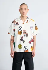 Camisa de manga corta color crema con estampado de objetos varios.