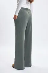 Pantalon deportivo de corte ancho y tiro alto, con efecto lavado en color verde. Presenta cintura elástica con cordón ajustable y aberturas laterales en el ruedo.