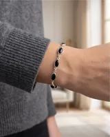 Pulsera de plata 925 con eslabones que sostienen piedras ovaladas de ónix negro. Diseño elegante y minimalista con cierre de seguridad.