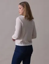 Cardigan de tejido tweed celeste y blanco, con escote redondo, cierre frontal con botones metálicos dorados y bolsillos simulados en el frente.