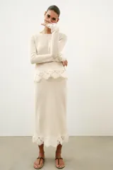 Falda midi de tejido rústico en color beige, con tiro medio, cintura elástica y detalle de aplicación de crochet en el bajo.