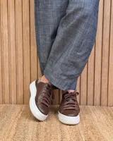Pantalón de lino color marrón con corte barrel, tiro medio, cintura elástica con cordón de ajuste y bolsillos laterales.